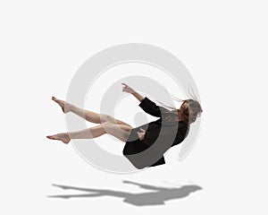 Soar up. Young beautiful girl, female ballet dancer dancing isolated over white background with shadow.