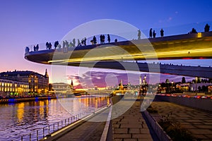 The `Soaring bridge` with people above Moscow river in the park `Zaryadye` near Red Square. Landscape with night view.