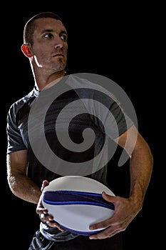 Sober rugby player holding ball