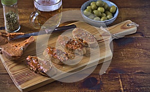 Sobrasada toast with oregano, accompanied by beer and olives