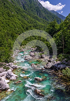 Soca Valley, Slovenia - Aerial panoramic view of the emerald alpine river Soca on a bright sunny summer day with green foliage.