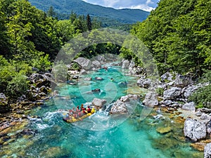 Soca Valley, Slovenia - Aerial view of the emerald alpine river Soca with rafting boats going down the river on a sunny summer day