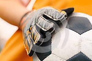 Soccer background detail image. Close up on football ball and sports goalie gloves