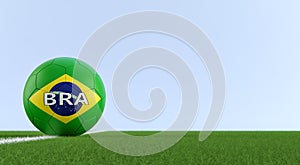 Soccer ball in brazils national colors on a soccer field. Copy space on the right side - 3D Rendering