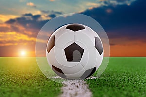 Soccer ball on soccer field at sunset