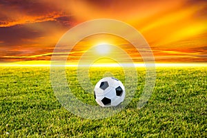 Soccer ball on the field with sunset