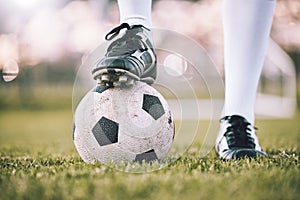 Soccer ball, football player shoes and grass field of athlete feet ready for exercise and sport. Fitness, lawn and