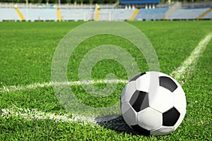 Soccer ball on fresh green football field grass.