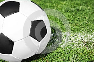 Soccer ball on fresh green football field grass