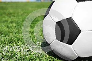 Soccer ball on fresh green football field grass, closeup