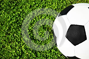 Soccer ball on fresh green football field grass, top view