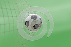 Soccer ball in goal with grass leaves that raises effect on blur