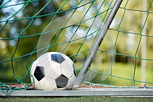 Soccer ball at goal net on football field