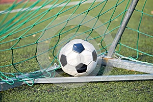 Soccer ball at goal net on football field