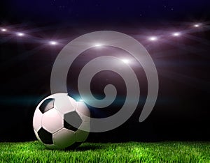 Soccer ball on grass against black