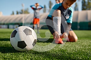 Soccer ball on grass and children football team training