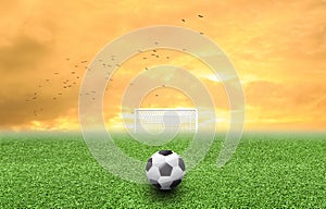 Soccer ball on grass sunset