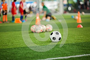 Soccer ball on green artificial turf with blurry soccer team training