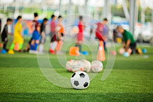 Soccer ball on green artificial turf with blurry soccer team training