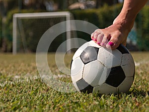 Soccer ball in a green field near a five-a-side goal, outdoor