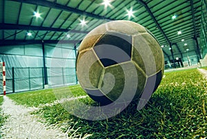 Soccer ball on green grass in an indoor playground