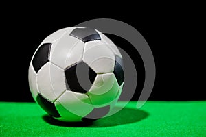 soccer ball on green grass over black background