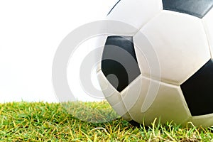 Soccer ball on green grass on white background
