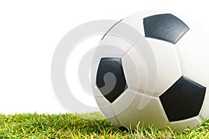 Soccer ball on green grass on white background