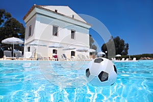 Soccer ball lies in water in pool