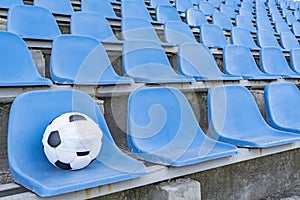 Soccer ball in a medical mask on the background of empty stands .