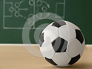 Soccer ball near chalkboard with football game scheme