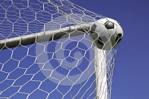 Soccer ball in net goal.