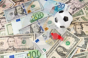 Soccer ball over a lot of money. corruption football game. Betting and gambling concept.