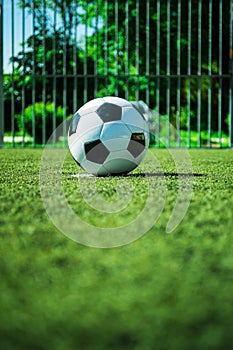 Soccer ball on penalty spot in cage football ground, street soccer in summer