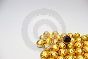 Soccer Ball-shaped chocolates in gold foil on a white background