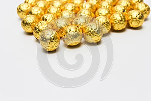 Soccer Ball-shaped chocolates in gold foil on a white background