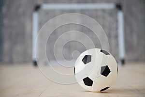 A soccer ball in a small gate on a gray background. Mini football.