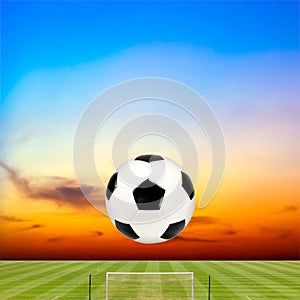 Soccer ball with soccer field against beautiful sunset