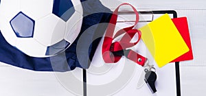 Soccer ball, sports shorts, a writing pad, two penal cards and a whistle on a red ribbon for the judge, on a gray background