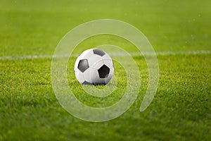 The Soccer Ball On Stadium Green Field. Football Pitch in the Background