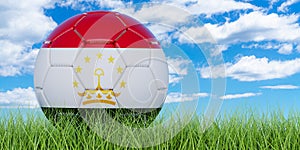 Soccer ball with Tajik flag on the green grass against blue sky, 3D rendering