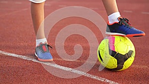 Soccer ball with their feet boy on the football field.