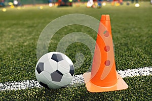 Soccer Ball and Training Cone Lying on Football Pitch Sideline photo