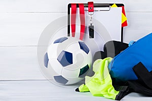 Soccer ball, whistle, penalty cards and a tablet for recording a judge and sportswear in a bag, on a gray background