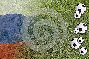 Soccer balls on green lawn with Russian flag