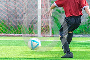 Soccer boy training kicking the ball in soccer training field