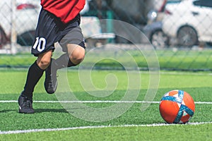 Soccer boy training kicking the ball in soccer training field