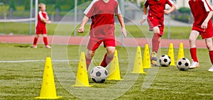 Soccer camp for kids. Boys practice dribbling in a field. Players develop good soccer dribbling skills