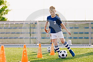 Soccer camp for kids. Boys practice dribbling in a field. Players develop good soccer dribbling skills