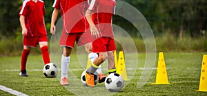 Soccer camp for kids. Children training soccer skills with balls and cones